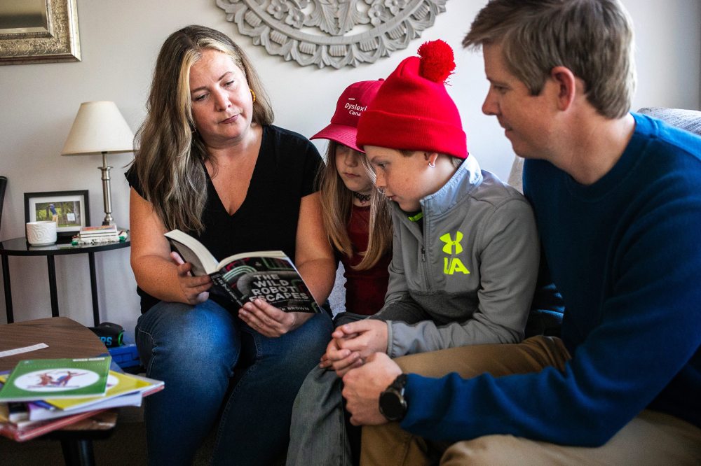 MIKAELA MACKENZIE / FREE PRESS
Carrie (left) and Alden Wood (right) read books with their with children Joey, age seven and Emmett, 11.