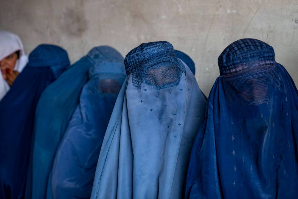 EBRAHIM NOROOZI / ASSOCIATED PRESS FILES
Afghan women wait to receive food rations distributed by a humanitarian aid group in Kabul, Afghanistan.