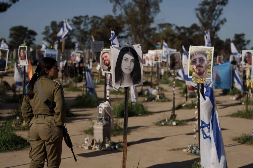 A woman, a member of the Israeli forces, visits the site where revellers were killed and kidnapped on Oct. 7 in a cross-border attack by Hamas militants at the Nova music festival near the kibbutz Reim, southern Israel, in March. (Leo Correa / The Associated Press files)
