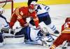 JEFF MCINTOSH / THE CANADIAN PRESS
                                Goalie Connor Hellebuyck dives for the puck as Calgary Flames’ Sam Honzek (left) is is checked into him by Dylan Samberg during the third period in Calgary on Friday.