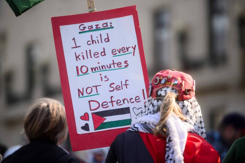 MIKE SUDOMA / FREE PRESS
Pro-Palestinian protesters hold signs and fly Palestinian flags during a rally at the Manitoba legislature on Saturday.