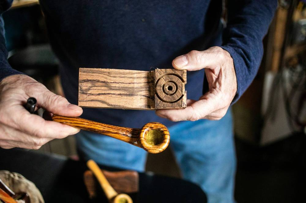 MIKAELA MACKENZIE / WINNIPEG FREE PRESS
Jeff Nelson shows off a finished pipe alongside one currently in progress.