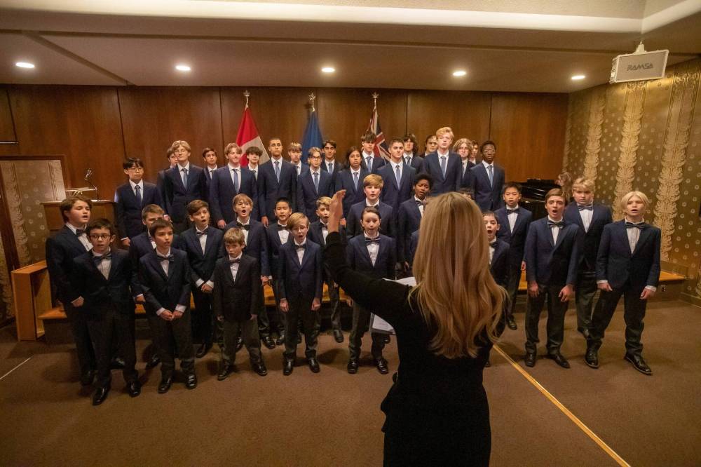 Artistic director Carolyn Boyes leads the boys choir during a concert at Government House. (Brook Jones / Free Press)