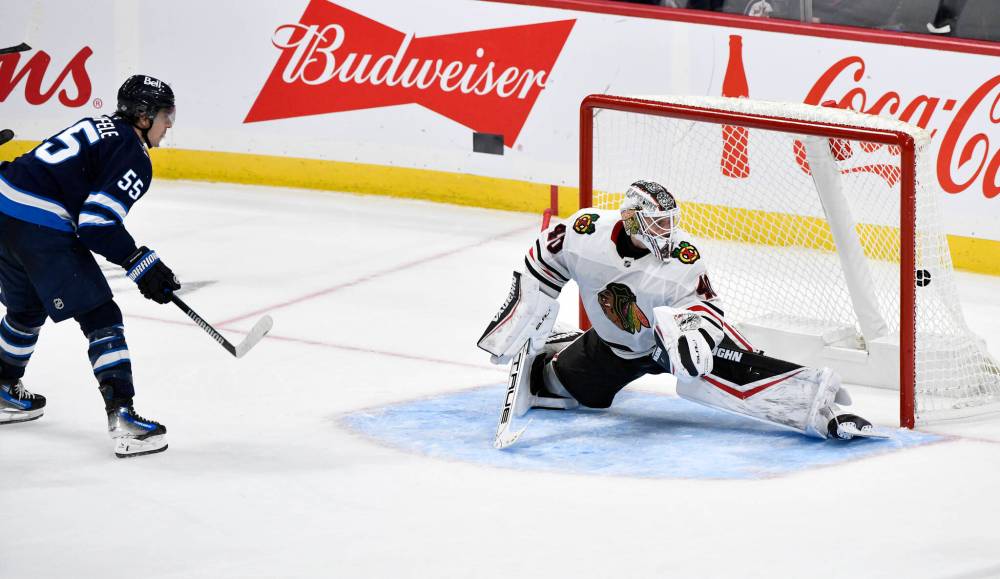 FRED GREENSLADE / THE CANADIAN PRESS
Mark Scheifele (left) snaps a shot past Blackhawks goaltender Arvid Soderblom to lift the Jets to a 2-1 overtime win Friday night.