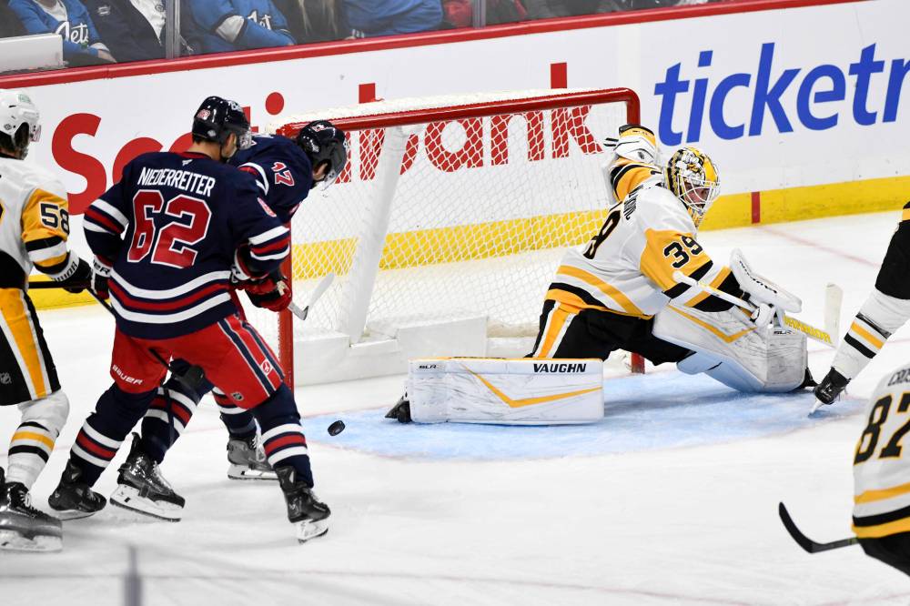 Fred Greenslade/ THE CANADIAN PRESS
Adam Lowry (second from right) scores Sunday against the Pittsburgh Penguins as the Jets came back from a 2-0 deficit to win 6-3.