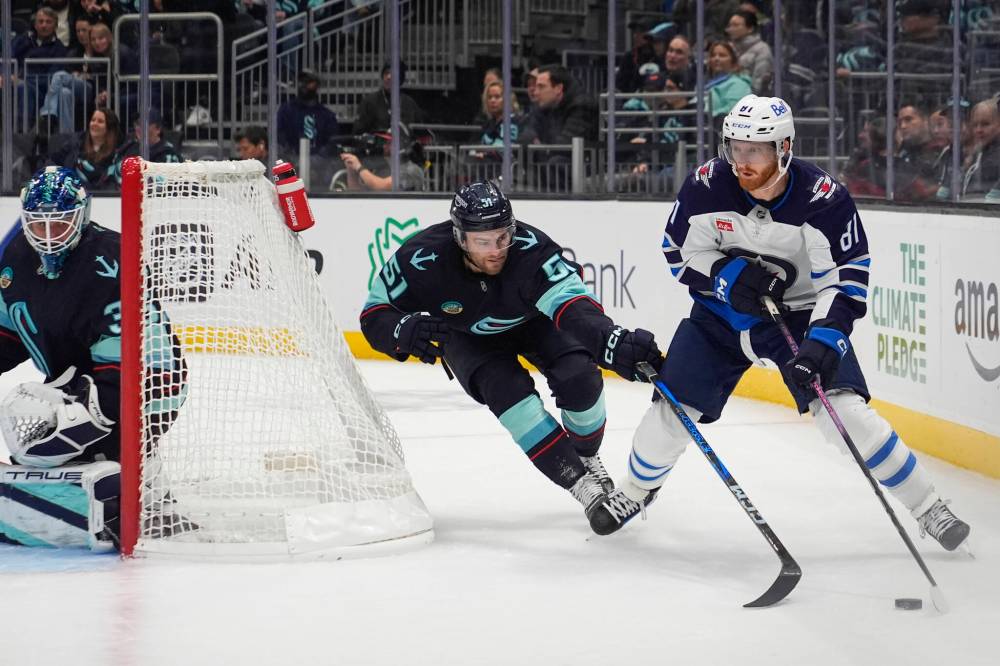Lindsey Wasson / The Associated Press
Seattle Kraken’s Shane Wright reaches for the puck against Winnipeg Jets winger Kyle Connor, during the first period.