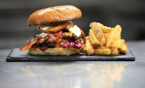 Ruth Bonneville / Free Press
                                Woodbine Burgers&rsquo; signature creation, the Smashzilla, features two Wagyu smash patties topped with cheddar cheese, bacon, chipotle aioli, blueberry mayo, fried onion rings and butter pickles on a toasted brioche bun.