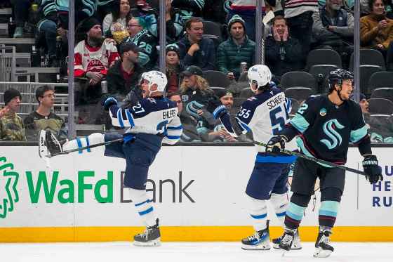 Winnipeg Jets left wing Nikolaj Ehlers, left, celebrates his game-winning goal with teammate Mark Scheifele (55) as Seattle Kraken defenseman Brandon Montour (62) looks away during overtime Thursday. (Lindsey Wasson / The Associated Press files)