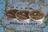 Canadian dollar coins are displayed on a map of North America, in Montreal, in a Jan. 9, 2014, photo illustration. Experts say Donald Trump’s election victory could shift interest rate policy in the U.S., as his promised policies risk higher inflation and could weigh on the Canadian dollar. THE CANADIAN PRESS/Paul Chiasson