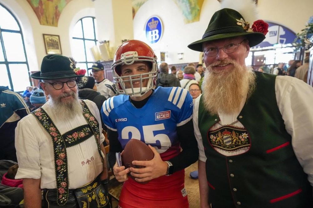 People in Bavarian clothes pose with a NFL supporter inside the traditional 'Hofbraeuhaus' in Munich, Germany, Saturday, Nov. 9, 2024 ahead of the NFL match between the Carolina Panthers and the New York Giants in Munich on Sunday. (AP Photo/Matthias Schrader)