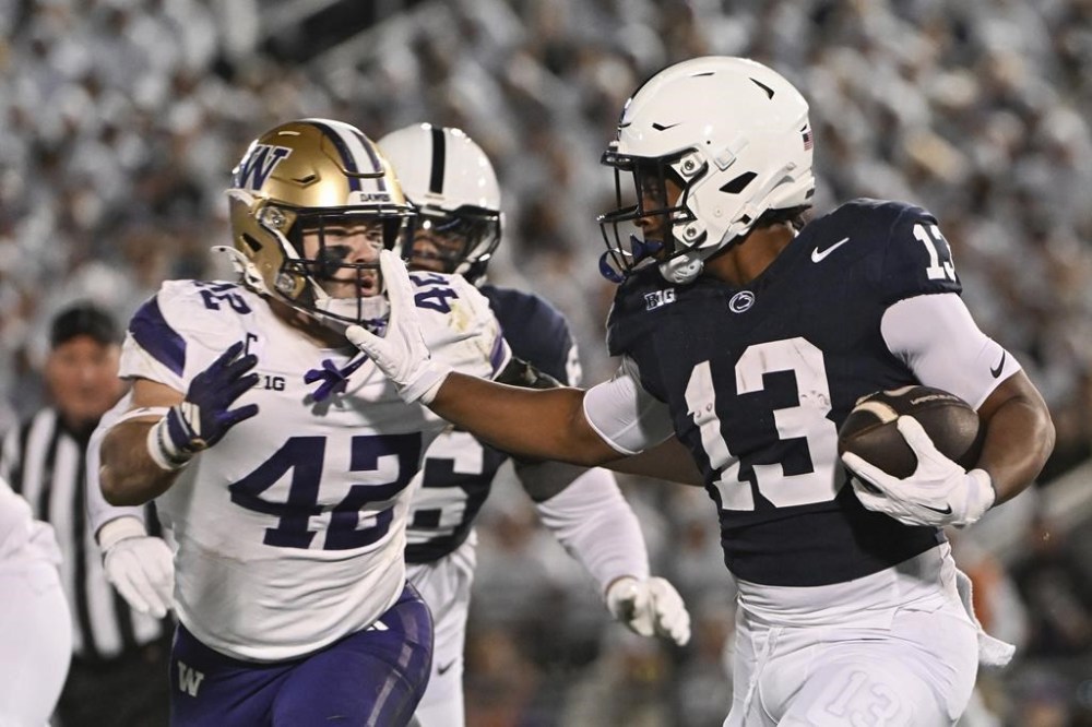 Penn State running back Kaytron Allen (13) stiff-arms Washington linebacker Carson Bruener (42) during the first quarter of an NCAA college football game, Saturday, Nov. 9, 2024, in State College, Pa. (AP Photo/Barry Reeger)