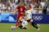 Canada's Janine Beckie fights for the ball with Germany's Giulia Gwinn and Janina Minge during a women's quarterfinal soccer match between Canada and Germany at the 2024 Summer Olympics, Saturday, Aug. 3, 2024, at Marseille Stadium in Marseille, France. THE CANADIAN PRESS/AP/Daniel Cole