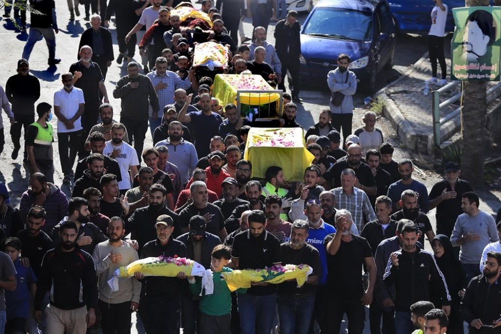 Mourners carry the bodies of victims who were killed on Monday evening in an Israeli airstrike, during a mass funeral in Saksakiyeh village, south Lebanon, Wednesday, Nov. 13, 2024. (AP Photo/Mohammed Zaatari)