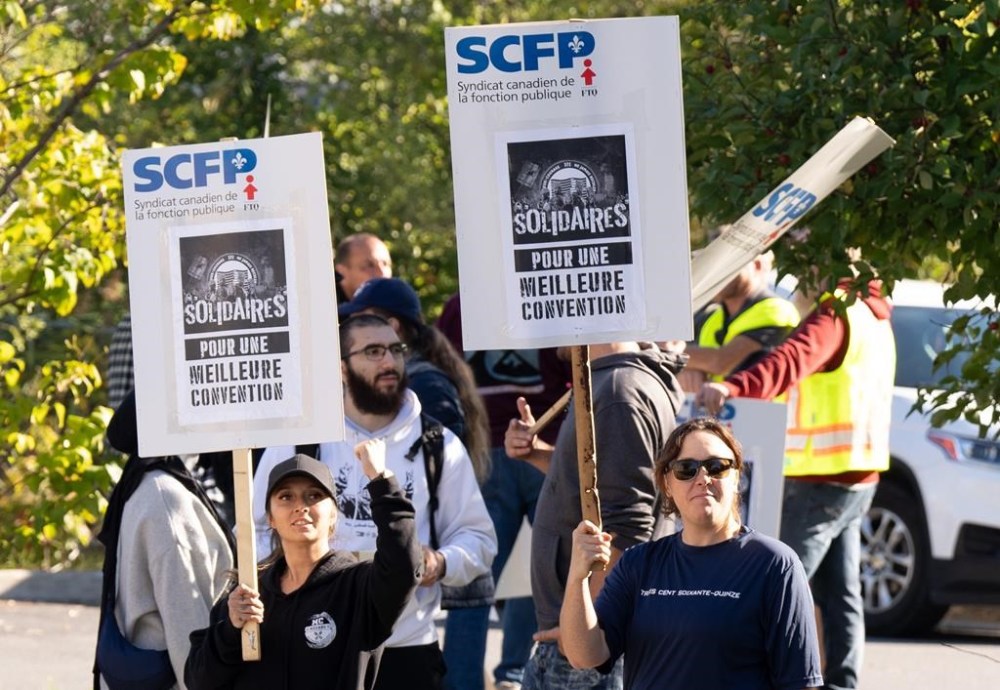 Port of Montreal workers walk a picket line outside the Maisonneuve Termont terminal in Montreal, Monday, Sept. 30, 2024. The union representing Montreal dock workers plans a court challenge to a decision by the federal labour minister to end a lockout at the port by sending the dispute to binding arbitration.THE CANADIAN PRESS/Christinne Muschi