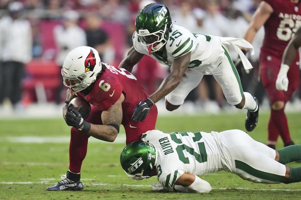 Arizona Cardinals running back James Conner (6) is hit by New York Jets cornerback Isaiah Oliver (23) during the second half of an NFL football game, Sunday, Nov. 10, 2024, in Glendale, Ariz. (AP Photo/Ross D. Franklin)