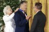 FILE - President George W. Bush, right, presents the Presidential Medal of Freedom to baseball great Ted Williams as Barbara Bush ties the medal around his neck Monday, Nov. 18, 1991, at a White House ceremony in Washington. (AP Photo/Marcy Nighswander, File)