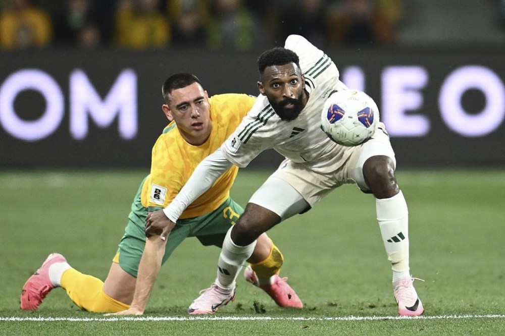Australia's Lewis Miller, left, and Saudi Arabia's Feras Albrikan compete for the ball during the 2026 World Cup qualifier between Australia and Saudi Arabia in Melbourne, Australia, Thursday, Nov. 14, 2024. (Joel Carrett/AAP Image via AP)