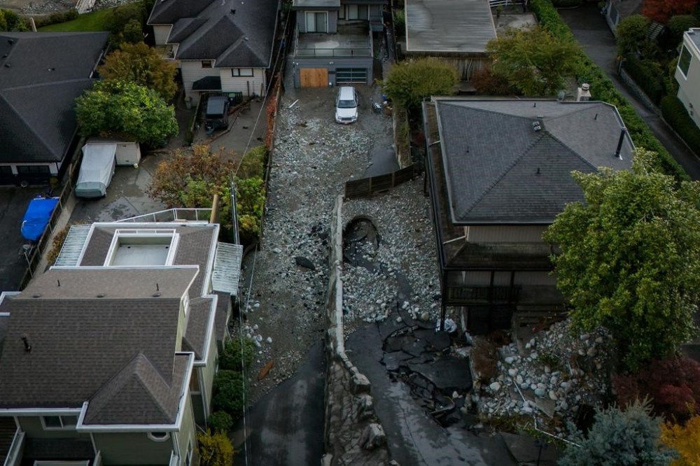 Multiple homes are seen surrounded by debris left by flooding from torrential rain in Deep Cove in North Vancouver, on Oct. 22. THE CANADIAN PRESS/Ethan Cairns