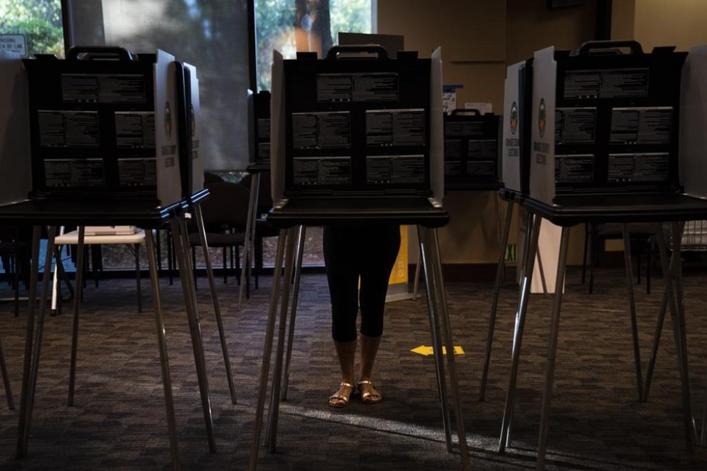 FILE - A voter casts her ballet at a vote center, Tuesday, Sept. 14, 2021, in Huntington Beach, Calif. (AP Photo/Jae C. Hong, File)