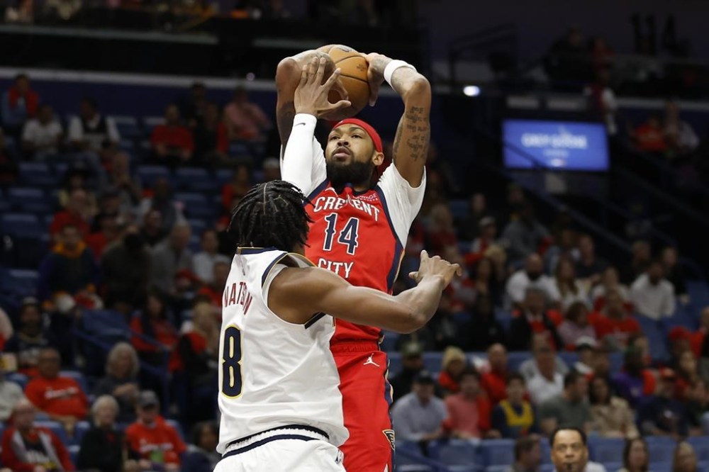 New Orleans Pelicans forward Brandon Ingram (14) shoots a basket over Denver Nuggets forward Peyton Watson (8) in the first half of an NBA basketball game in New Orleans, Friday, Nov. 15, 2024. (AP Photo/Tyler Kaufman)