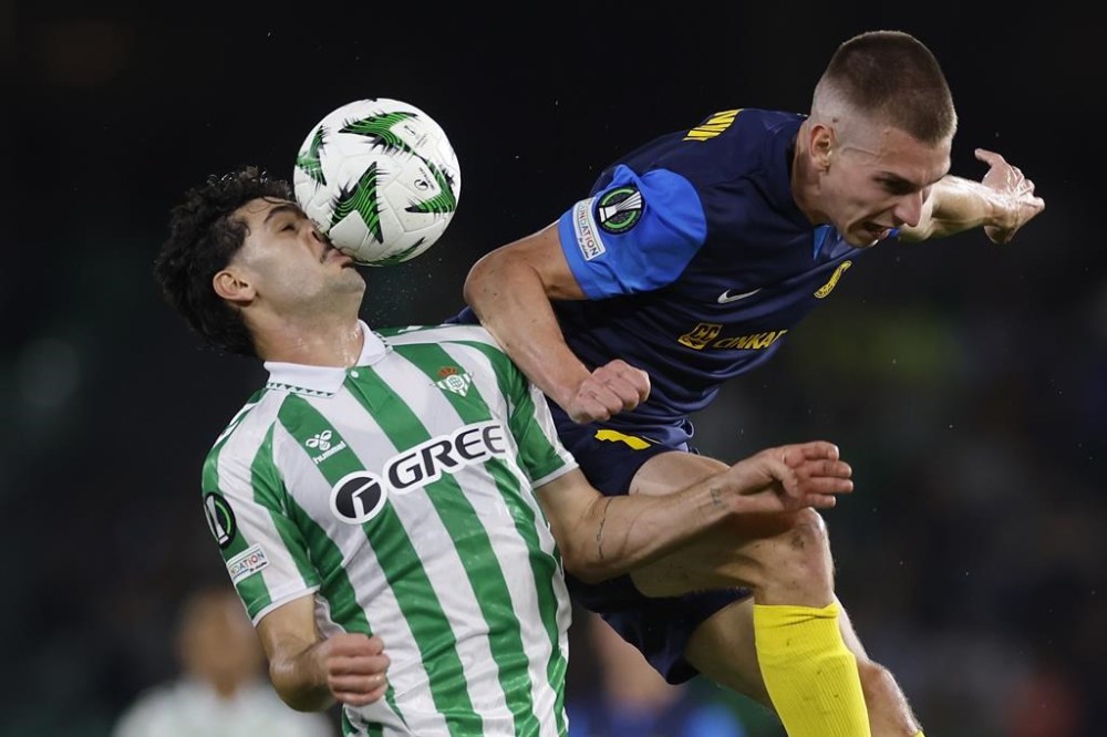 Betis' Johnny Cardoso, left, challenges for the ball with Celje's Mark Zabukovnik during a Conference League soccer match between Betis and Celje at the Benito Villamarin stadium in Seville, Spain, Thursday, Nov. 7, 2024. (AP Photo/Angel Fernandez)