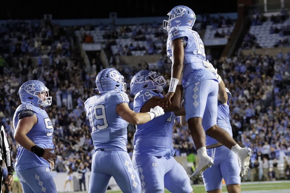 North Carolina quarterback Jacolby Criswell (12) is congratulated by teammates after he scored a touchdown against Wake Forest during the first half of an NCAA college football game Saturday, Nov. 16, 2024, in Chapel Hill, N.C. (AP Photo/Chris Seward)