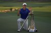 Rory McIlroy of Northern Ireland poses with the DP World Tour Championship trophy and the Race to Dubai trophy after winning the World Tour Golf Championship in Dubai, United Arab Emirates, Sunday, Nov. 17, 2024. (AP Photo/Altaf Qadri)