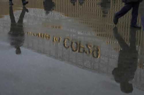 Attendees arrive at the venue as it rains during the COP29 U.N. Climate Summit, Monday, Nov. 18, 2024, in Baku, Azerbaijan. (AP Photo/Peter Dejong)