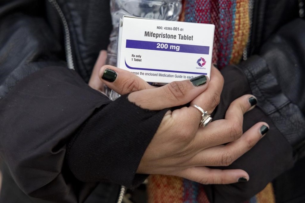 An abortion-rights activist holds a box of mifepristone pills as demonstrators from both anti-abortion and abortion-rights groups rally outside the Supreme Court in Washington, Tuesday, March 26, 2024. THE CANADIAN PRESS/AP-Amanda Andrade-Rhoades