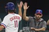FILE - Texas Rangers' Charlie Culberson (11) gets a high five from manager Chris Woodward after scored on a sacrifice bunt by teammate Bubba Thompson during the fourth inning of a baseball game against the Seattle Mariners in Arlington, Texas, on Aug. 13, 2022. (AP Photo/LM Otero, File)