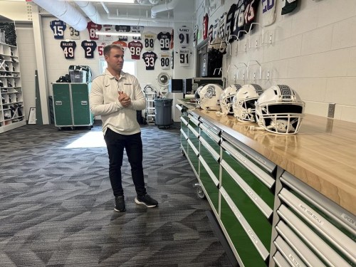 Andrew Kolpacki, Michigan State University's head football equipment manager, surveys players' helmets located on a table inside the school's football complex, Monday, Nov. 18, 2024, in East Lansing, Mich. (AP Photo/Mike Householder)