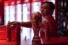 FILE - A bartender clears bottles of Budweiser beer from the bar near a replica of the FIFA World Cup trophy at an official U.S. Soccer fan party at the Budweiser World Club, in Doha, Sunday, Nov. 20, 2022. (AP Photo/Ashley Landis, File)