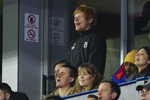 Ipswich Town fan Ed Sheeran, top, cheers for his team during the English Premier League soccer match between Ipswich Town and Manchester United at Portman Road stadium in Ipswich, England, Sunday, Nov. 24, 2024. (AP Photo/Dave Shopland)