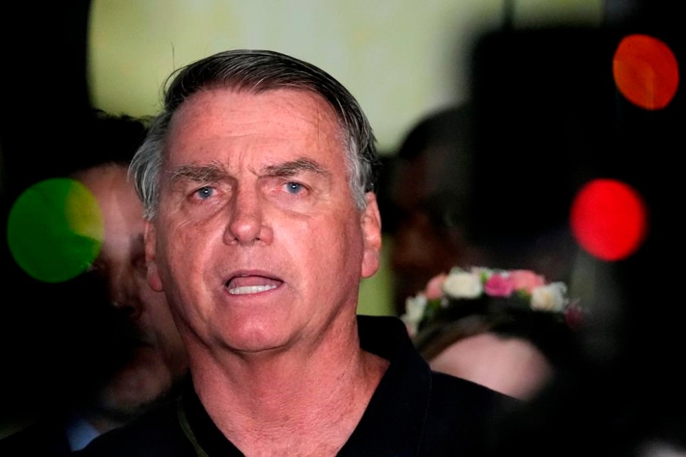 Former President Jair Bolsonaro speaks to the press after being formally charged by the federal police with attempted coup, at the airport in Brasilia, Brazil, Monday, Nov. 25, 2024. (AP Photo/Eraldo Peres)