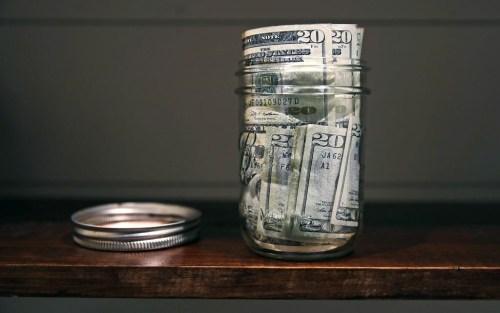 FILE - A canning jar filled with money sits on a shelf in East Derry, N.H., June 15, 2018. (AP Photo/Charles Krupa, File)