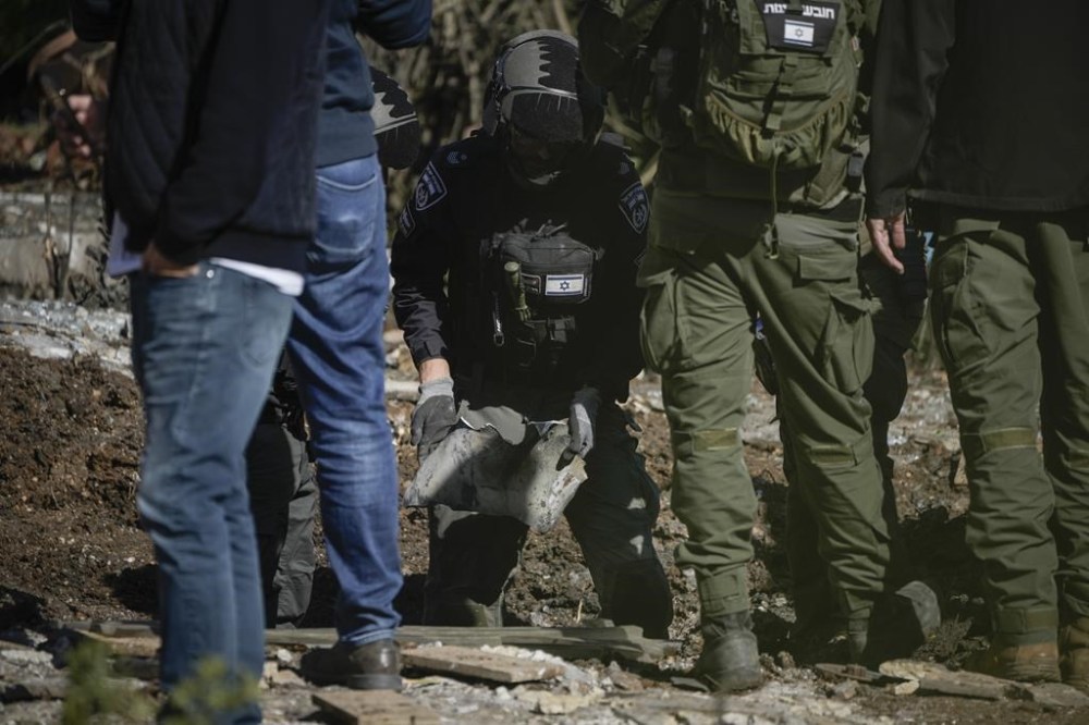 Police bomb squad officers collect the pieces of a rocket fired from Lebanon that landed in a backyard in Kiryat Shmona, northern Israel, Tuesday Nov. 26, 2024. (AP Photo/Leo Correa)