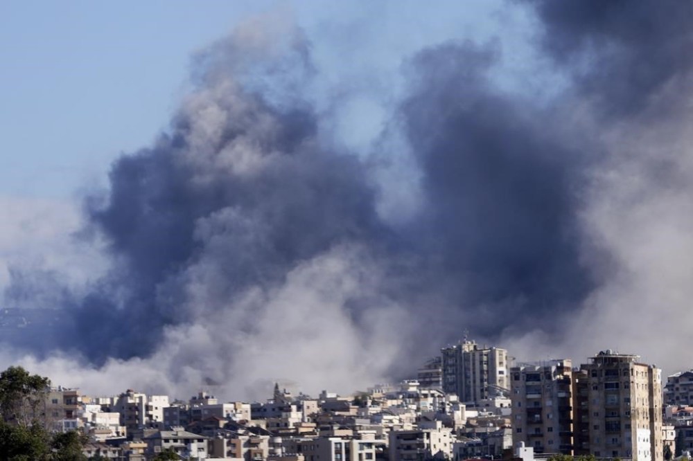 Smoke rises between buildings hit in Israeli airstrikes in Hosh neighbourhood, in Tyre, south Lebanon, Tuesday, Nov. 26, 2024. (AP Photo/Hussein Malla)
