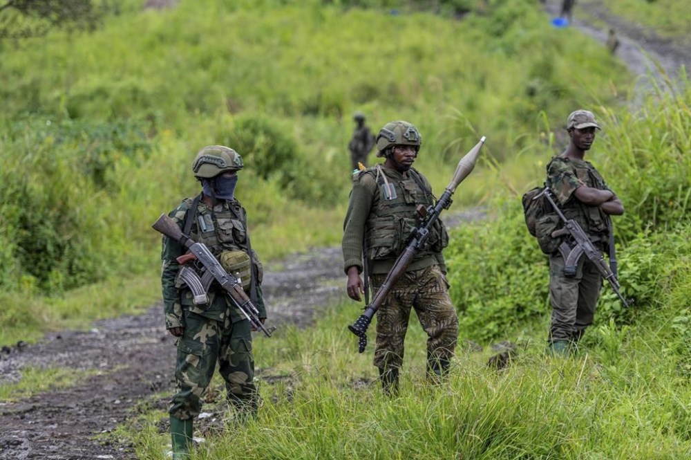 FILE - M23 rebels stand with their weapons in Kibumba, in the eastern of Democratic Republic of Congo, Dec. 23, 2022. (AP Photo/Moses Sawasawa, File)