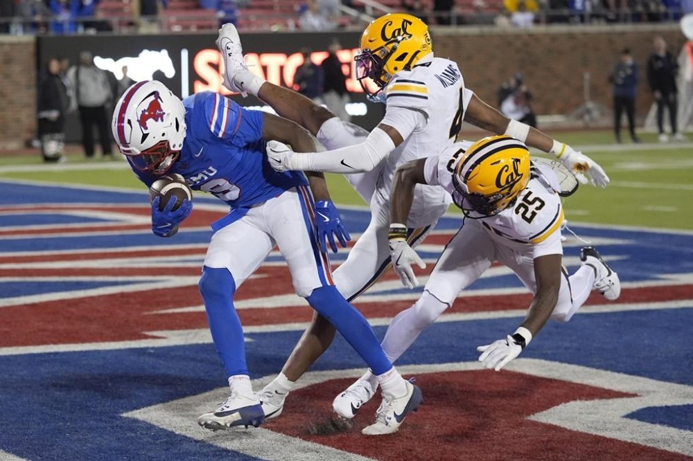 SMU wide receiver Key'Shawn Smith (9) pulls in a touchdown pass against California defensive backs Miles Williams (4) and Khamani Hudson (25) during the second half of an NCAA college football game Saturday, Nov. 30, 2024, in Dallas. (AP Photo/LM Otero)