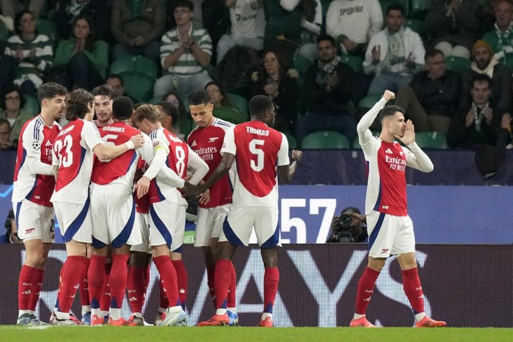 Arsenal's Gabriel Martinelli, right, celebrates after scoring the opening goal during the Champions League opening phase soccer match between Sporting CP and Arsenal at the Alvalade stadium in Lisbon, Tuesday, Nov. 26, 2024. (AP Photo/Armando Franca)