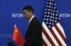 FILE - A Chinese official walks by the China and U.S. national flags before a meeting between Commerce Secretary Gina Raimondo and Chinese Minister of Commerce Wang Wentao at the Ministry of Commerce in Beijing on Aug. 28, 2023. (AP Photo/Andy Wong, Pool, File)