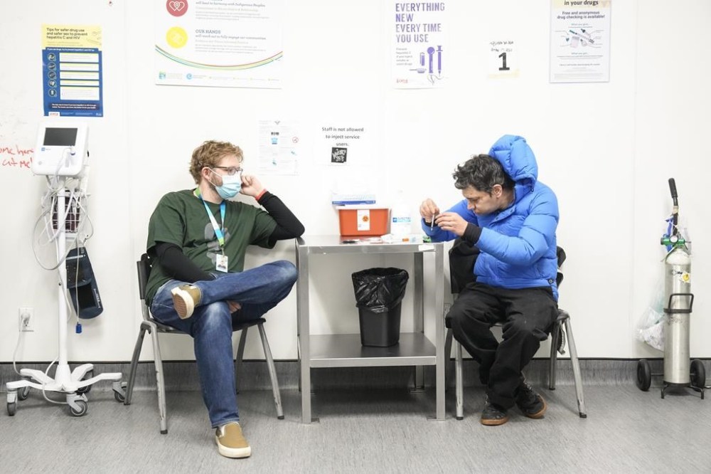 Community Health Worker Callan Pepper sits with a client in the consumption room at Moss Park Consumption and Treatment Service, in Toronto, Tuesday, Dec. 3, 2024. THE CANADIAN PRESS/Chris Young