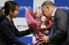 Los Angeles Dodgers manager Dave Roberts smells the bouquet of flowers he received during a press conference on the commercials he appears Wednesday, Dec. 4, 2024, in Tokyo. (AP Photo/Eugene Hoshiko)