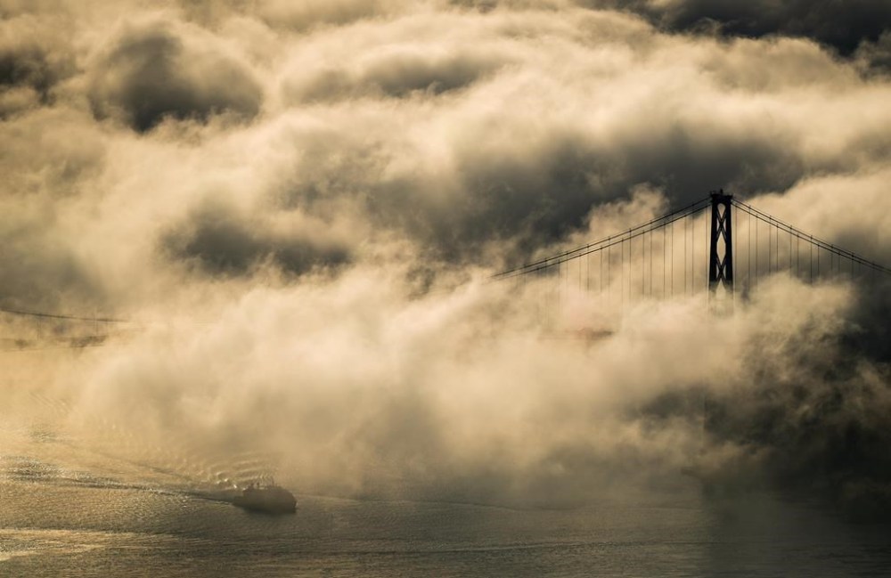 A Hullo Ferries passenger vessel passes under the Lions Gate Bridge as fog shrouds Burrard Inlet in Vancouver, B.C., Tuesday, Dec. 3, 2024. THE CANADIAN PRESS/Darryl Dyck