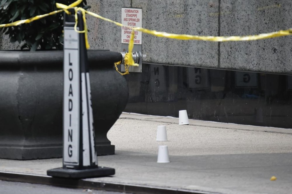Paper cups mark spots at the scene outside the Hilton Hotel in midtown Manhattan where Brian Thompson, the CEO of UnitedHealthcare, was fatally shot Wednesday, Wednesday, Dec. 4, 2024, in New York. (AP Photo/Stefan Jeremiah)