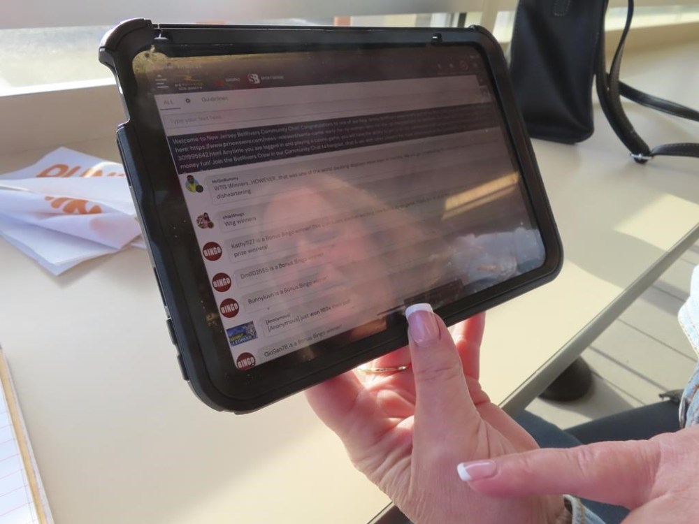 Elaine Vallaster looks at the screen of her computer tablet while playing an internet slots game in Hazlet, N.J. on Nov. 24, 2023. (AP Photo/Wayne Parry)
