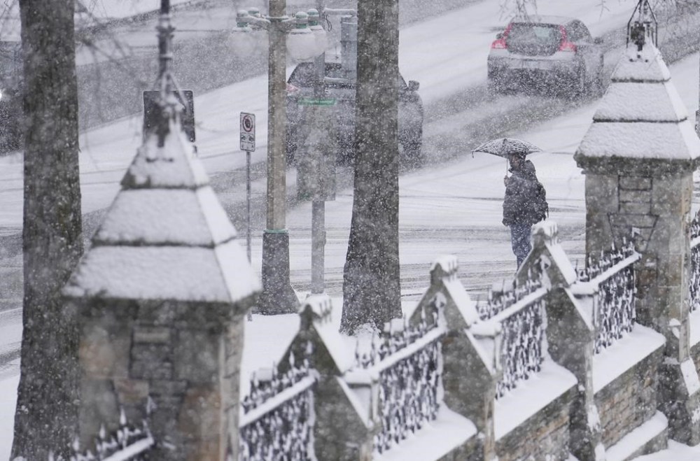 People make their way through the falling snow in downtown Ottawa, Wednesday, Dec. 4, 2024. THE CANADIAN PRESS/Sean Kilpatrick