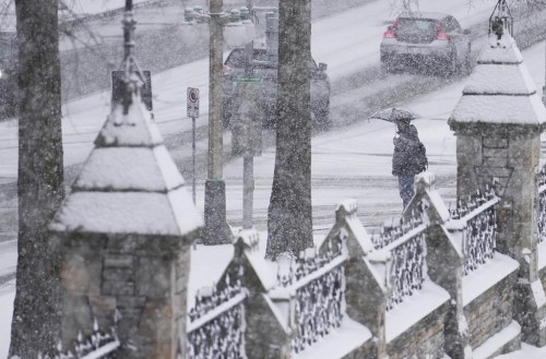 People make their way through the falling snow in downtown Ottawa, Wednesday, Dec. 4, 2024. THE CANADIAN PRESS/Sean Kilpatrick