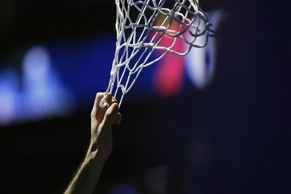 Orlando Magic's Goga Bitadze hangs from the net before an NBA basketball game against the Philadelphia 76ers, Wednesday, Dec. 4, 2024, in Philadelphia. (AP Photo/Matt Slocum)