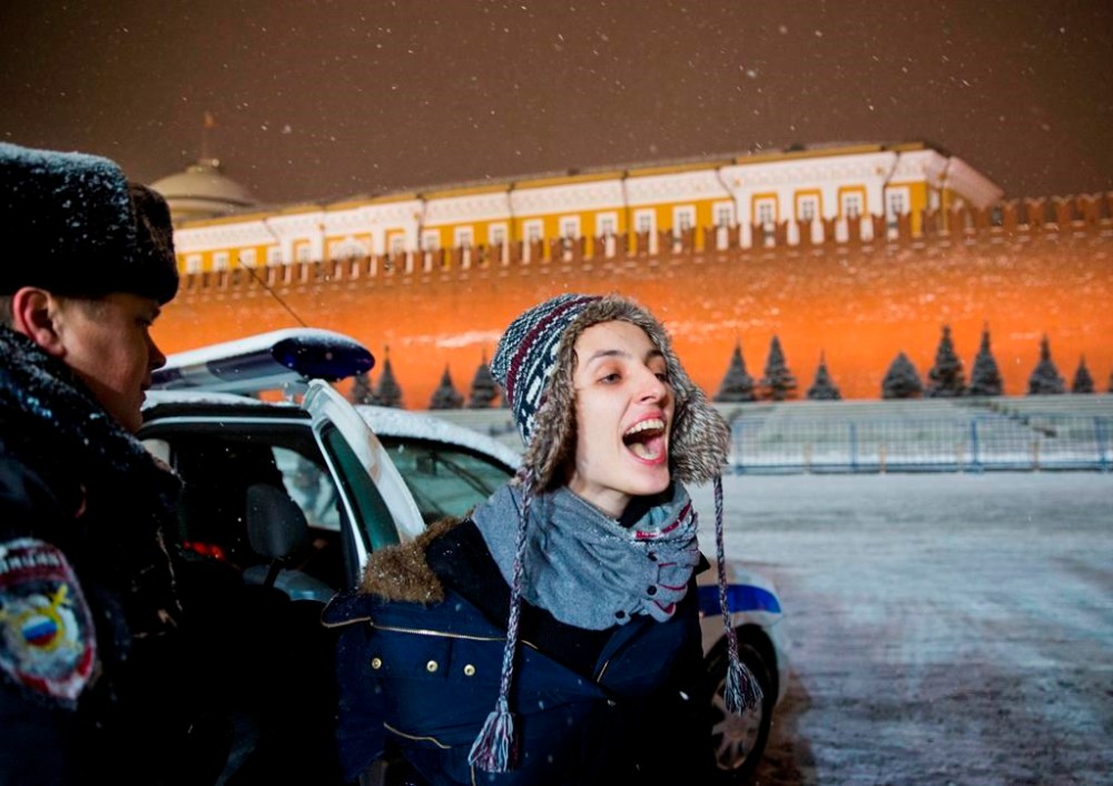 FILE - A police officer detains a gay rights activist in Red Square in Moscow on Feb. 7, 2014. (AP Photo/Evgeny Feldman, File)